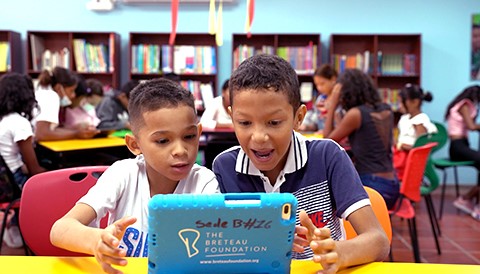 two kids sitting at table in a Community Center