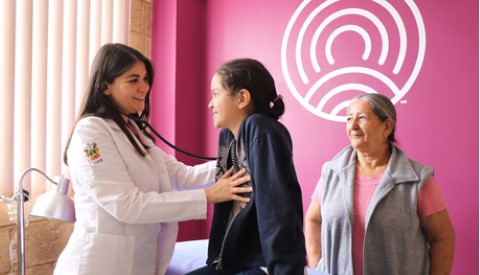a doctor listens to a girl's heartbeat with a stethoscope