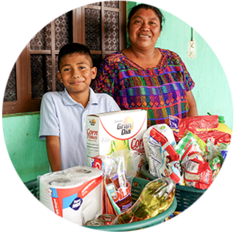 una mujer junto a un niño con alimentos donados