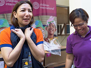 a woman in a orange shirt standing next to a woman in a purple shirt