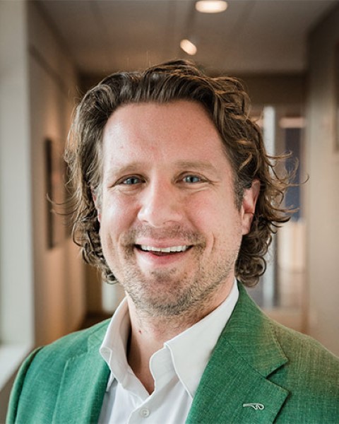 a man in a green suit is smiling for the camera