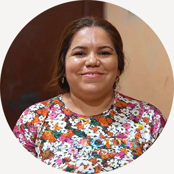 a woman in a floral shirt smiling at the camera