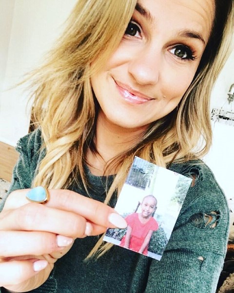 a woman holding up a picture of herself